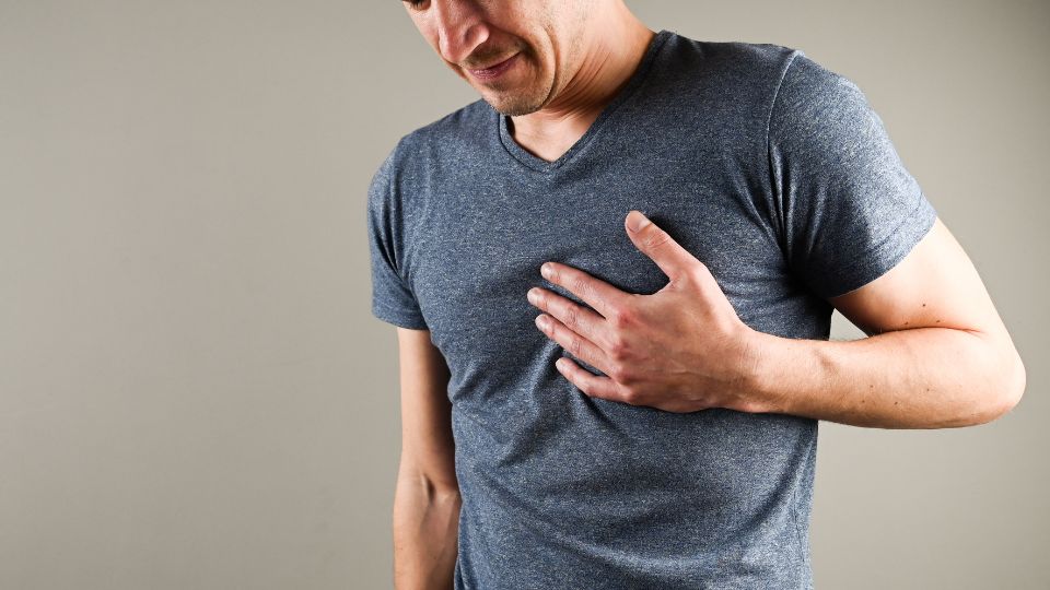 Homem com a mão no peito exemplificando doenças cardiovasculares.