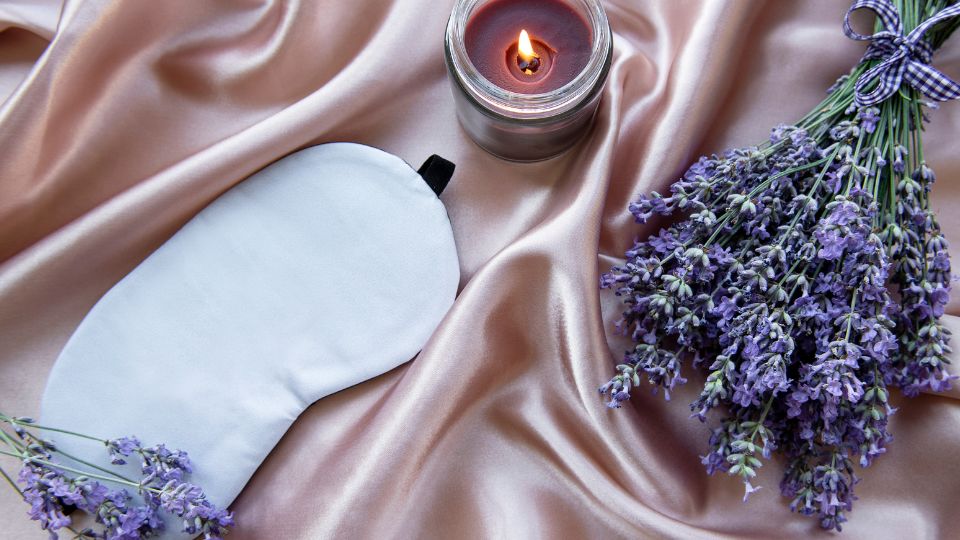 Imagem de máscara de dormir, vela aromática e lavanda para representar um ritual do sono.