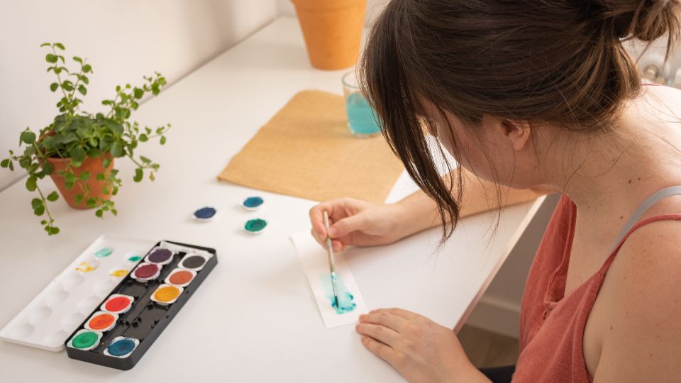 mulher colorindo papel usando tinta guache como uma técnica de relaxamento
