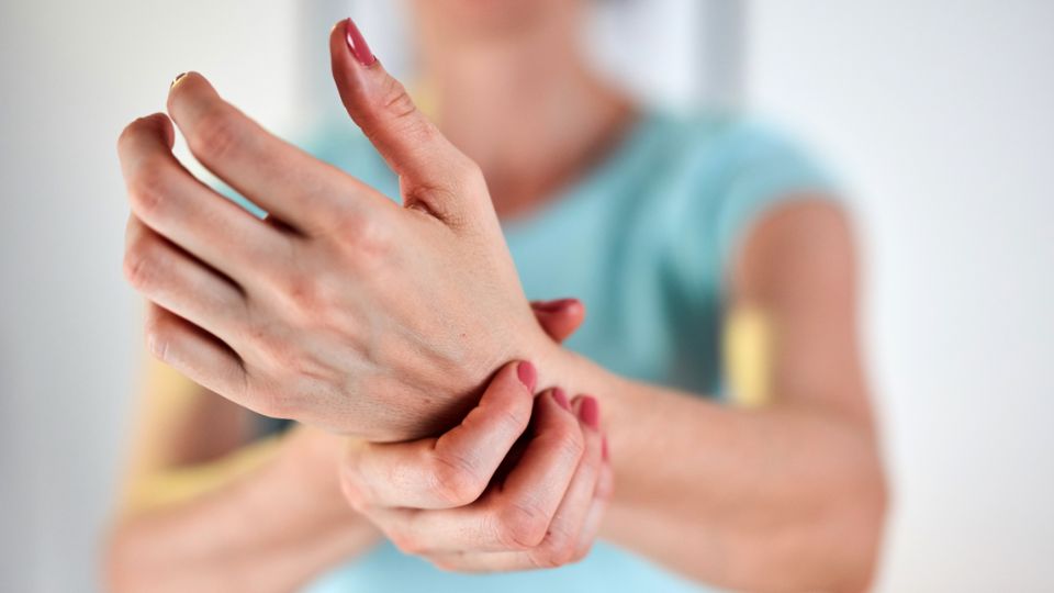 Pessoa segurando a mão com sensaçao de dor.
